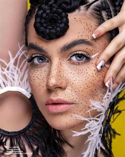 عکاسی پرتره زن زیبا با موهای بافته شده سیاه و کک و مک روی صورتش