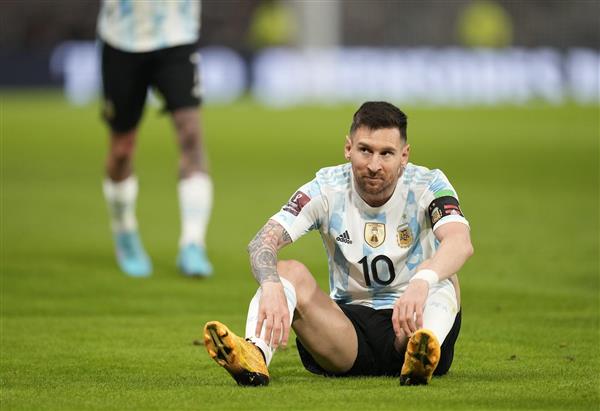 عکس مسی با لباس تیم آرژانتین نشسته روی زمینه چمن