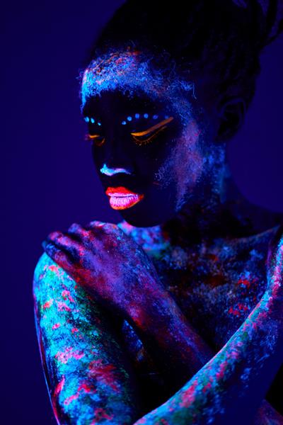 ژست مدل زن سیاهپوست جنسی با الگوی UV بر روی آرایش بدن فلورسنت بدن آرام آرام ب