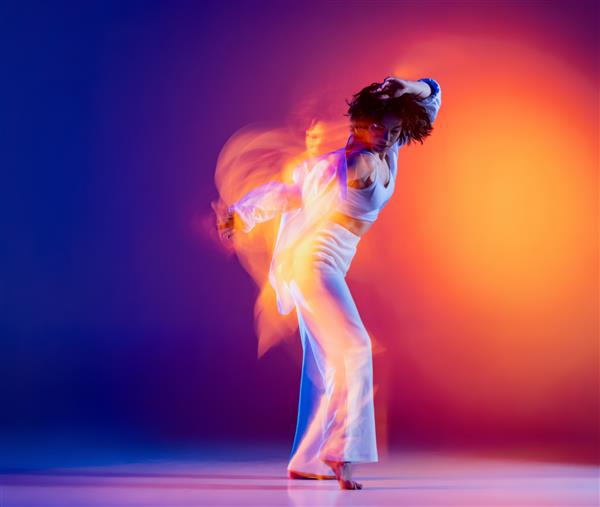 رقصنده رقصنده هیپوپ دختر زیبای ورزشی جوان و جدا شده روی پس زمینه بنفش در نور نئون