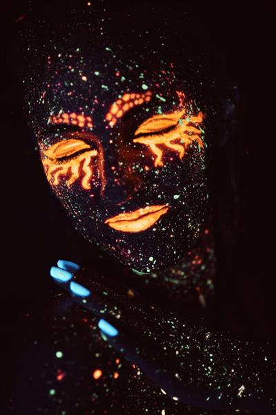 آرایش فرابنفش پرتره دختری که در پودر فلورسنت نقاشی شده است مفهوم هالووین کهکشان در خواب