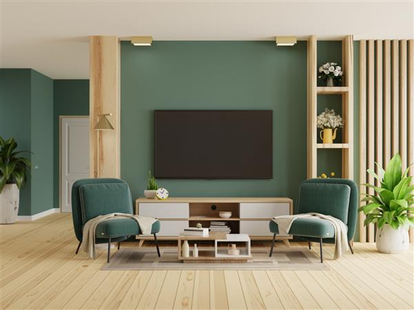 اتاق تلویزیون با دو صندلی راحتی سبز در پس زمینه دیوار سبز تیره خالی