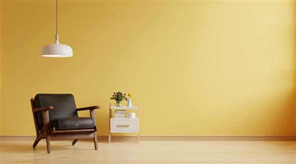 اتاق نشیمن یک صندلی راحتی چرمی تیره روی پس زمینه دیوار زرد خالی دارد