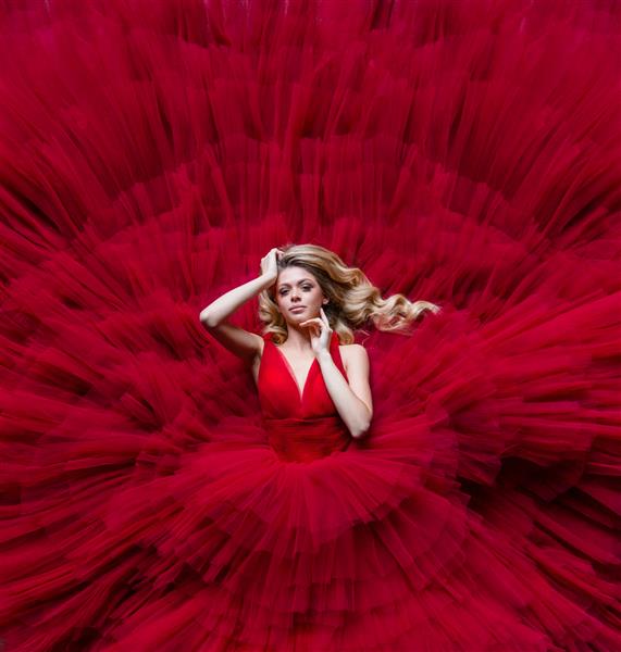 نمای هوایی از بلوند زیبا در لباس قرمزی قرار دارد که کل عکس را پر کرده است