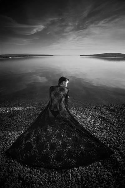 زن زیبای رمانتیک که در نزدیکی دریاچه برکه ای نشسته است زن مرطوب با لباس زیر زیر پرتوهای خورشید در غروب آفتاب موهای بلند زیبایی طبیعی