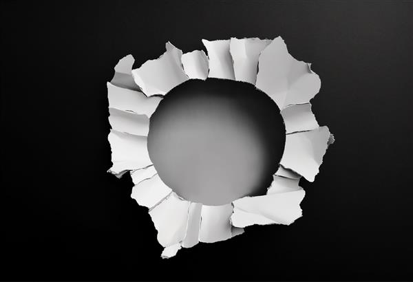 کاغذ پاره شده سفید در پس زمینه تیره با سوراخ در وسط