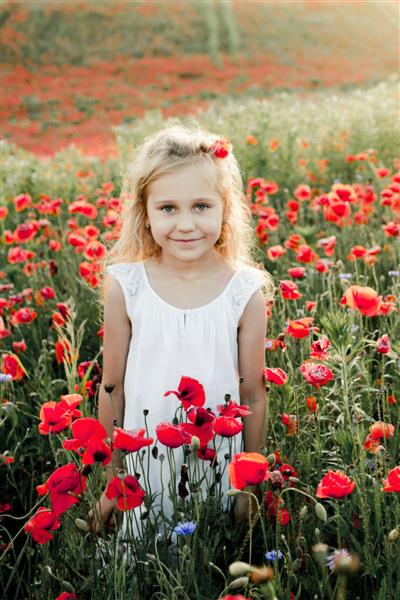 دختری در میان گل های خشخاش لبخند می زند