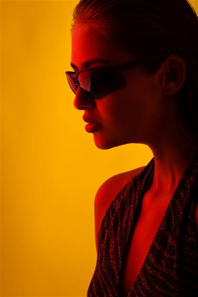 پرتره دختری با عینک آفتابی با نور قرمز