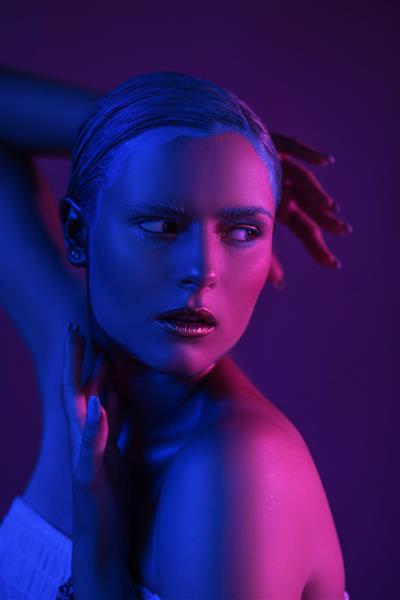 نورهای نئونی براق روی پوست مدل جوان سکسی در استودیو عکس