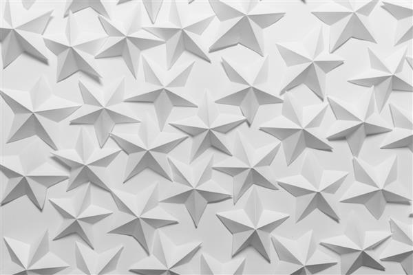 بسیاری از ستاره های کاغذی تا شده در پس زمینه سفید