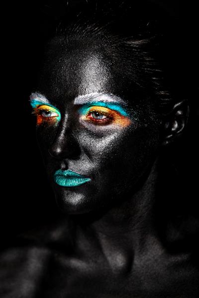زن مدل زیبا با ماسک سیاه غیرمعمول پلاستیکی خلاقانه آرایش رنگارنگ روشن با صورت سیاه