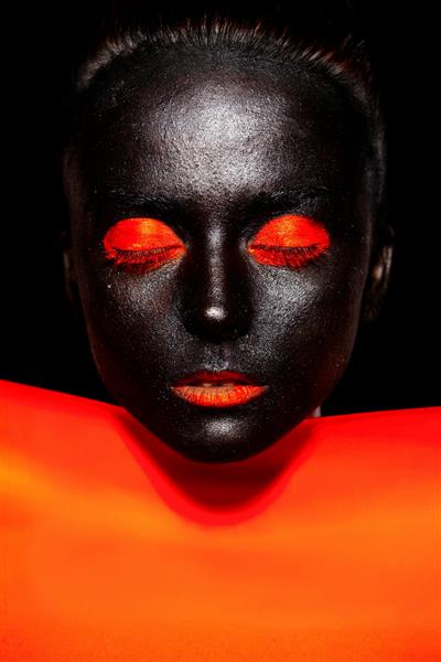 زن سیاه پوست زیبا با ماسک سیاه با آرایش و لب های روشن نارنجی
