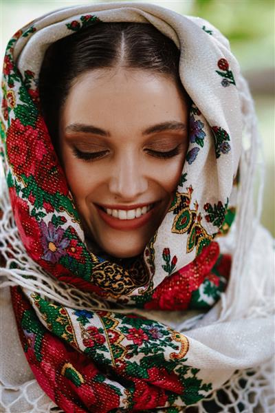 پرتره یک زن جوان خندان با لباس سنتی گلدوزی شده