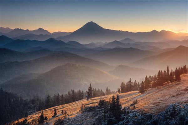 کوه های باستانی زیبا در سپیده دم در نور خورشید صبح و در مه