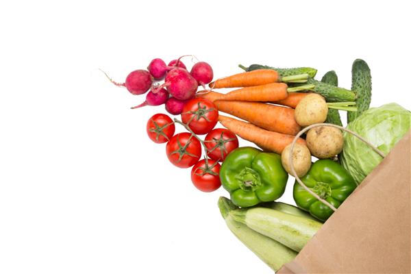 کیسه خرید کاغذی و سبزیجات ارگانیک تازه روی یک پشتی سفید