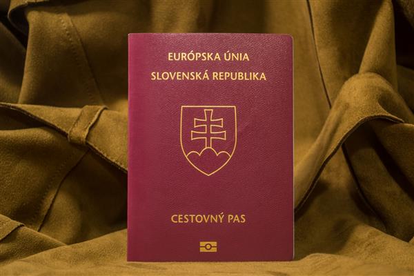 پاسپورت اسلواکی روی پس‌زمینه چرمی قهوه‌ای روشن ایستاده است