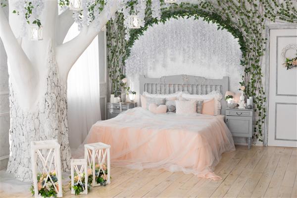فضای داخلی اتاق خواب یک تخت دو نفره پتو هلو درخت بزرگ سفید با گل در اتاق خواب درخت بزرگ در فضای داخلی