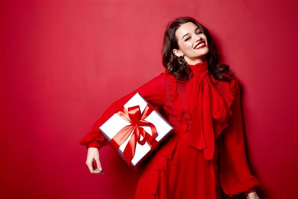 زن زیبا جوان سکسی با اندام لاغر آرایش شب شیک لباس شیک مجموعه لباس سبزه جعبه هدایایی کمان ابریشمی قرمز جشن جشن تولد سال نو کریسمس روز ولنتاین