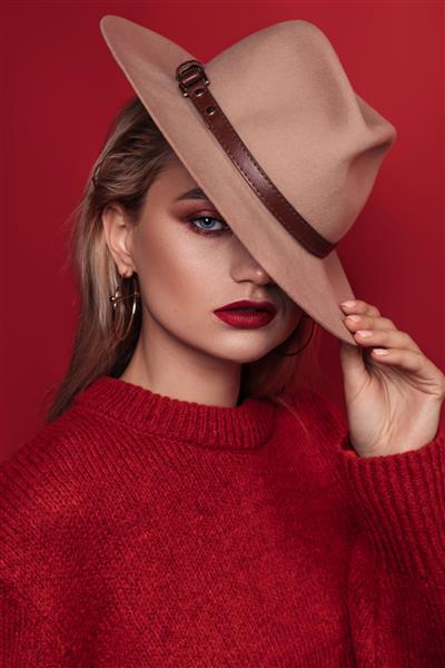 مدل مد با لب قرمز دختر شیک با کلاه پس زمینه قرمز