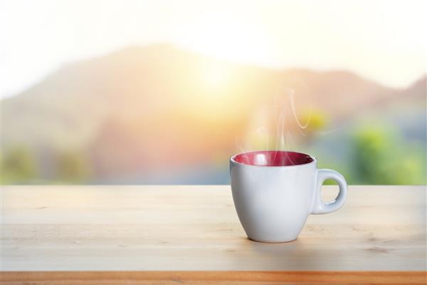 یک فنجان قهوه روی میز طلوع زیبای تار در بالای پس زمینه کوه فنجان قهوه صبح