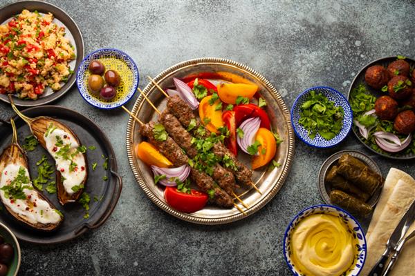 کباب گوشت لذیذ با سالاد سبزیجات تازه با انواع غذاهای خاورمیانه و پیش غذا سرو می شود نمای بالایی از انواع غذاهای عربی و مزه غذاهای خوشمزه و سالم مدیترانه ای