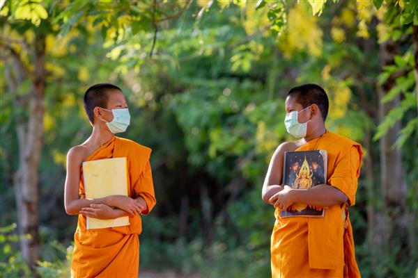 راهب تازه کار با ماسک فاصله اجتماعی و لذت بردن با دوست جدید مبتلا به کرونا یا کووید-19