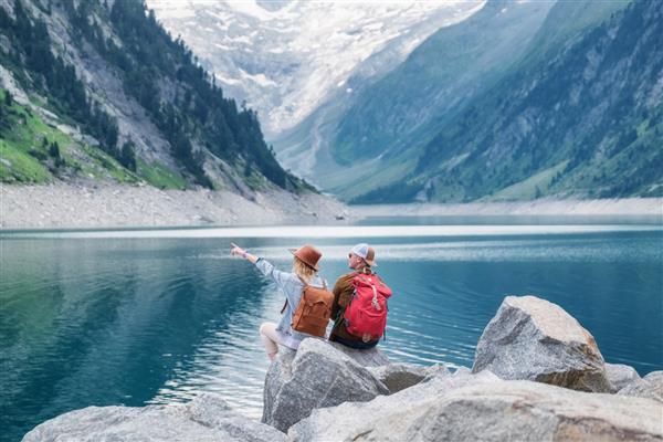 تصویر سفر تیم مسافران به چشم انداز کوه نگاه می کنند مفهوم سفر و زندگی فعال با تیم ماجراجویی و سفر در منطقه کوهستانی در اتریش