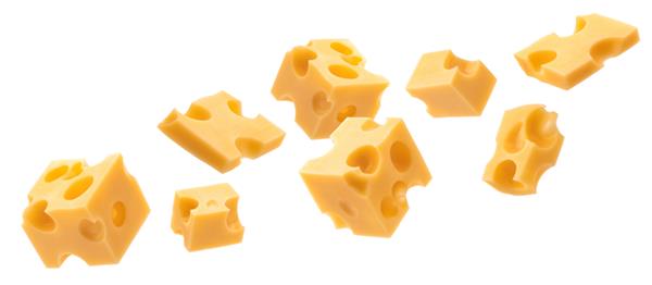 مکعب های پنیر در حال سقوط تکه های امنتال سوئیسی جدا شده در پس زمینه سفید با مسیر برش