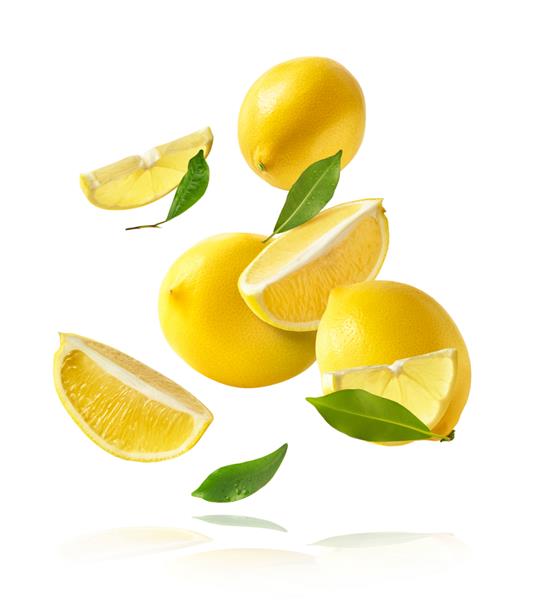 لیموهای تازه و کامل و برش خورده با برگ‌های سبزی که در هوا می‌افتند و در پس‌زمینه سفید جدا شده‌اند شناور شدن غذا یا تصور گرانش صفر تصویر با وضوح بالا