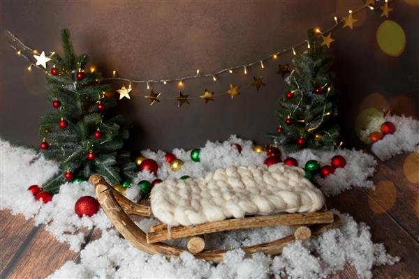 بافت پس زمینه عرشه از چوب ساخته شده است که با تزئینات کریسمس تزئین شده است سبد برای عکاسی نوزاد درخت کریسمس و اسباب بازی