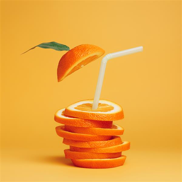 ترکیب تابستانی با تکه‌های پرتقال تازه و نی روی پس‌زمینه پرتقال پر جنب و جوش مفهوم خلاقانه رژیم غذایی سالم آب میوه های ارگانیک استوایی