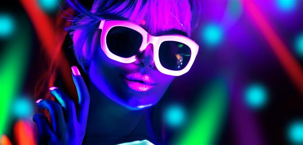 رقصنده دیسکو با نور نئون در کلوپ شبانه مدل مد زن در نور نئون پرتره دختر زیبا با آرایش فلورسنت طراحی بدنه در UV عینک آفتابی آرایش رنگارنگ