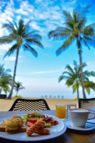 صبحانه با شکوه صبح زود در ساحل در تایلند اتاق صبحانه در ساحل صبحانه تازه در مکانی زیبا با منظره دریا تمرکز انتخابی