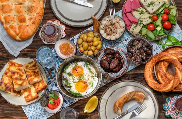 صبحانه سنتی ترکی غنی و خوشمزه شامل گوجه فرنگی خیار پنیر کره تخم مرغ عسل نان نان شیرینی زیتون و فنجان چای است سحر ماه رمضان یا سحور غذای صبح قبل از روزه