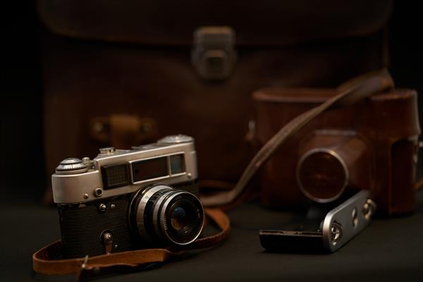 عکس دوربین فیلم قدیمی با قاب چرمی در پس‌زمینه مشکی