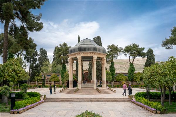 شیراز ایران - 1398 04 14 مردمی که در باغ ایرانی با آلاچیق سنگی قدم می زنند آرامگاه حافظ شیرازی شاعر نامدار ایرانی
