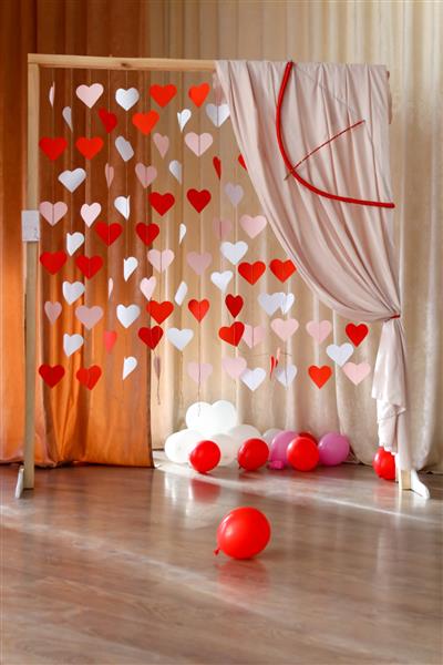 پس زمینه روز ولنتاین با قلب های کاغذی شکل‌های قلب قرمز و سفید روی پس‌زمینه طاق چوبی در مفهوم عاشقانه برای 14 فوریه مفهوم عشق بالن های هوا