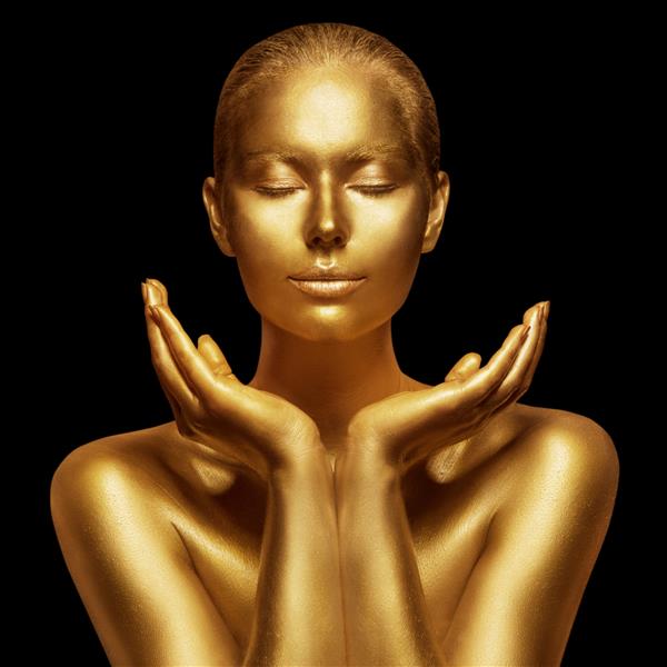 مدل زیبایی با پوست براق طلایی صورت زن با چشمان بسته و کف دست های باز پرتره هنری طلایی روی مشکی