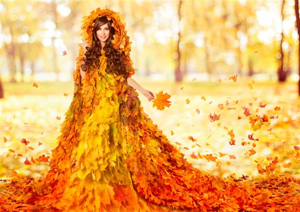 مدل مد پاییزی در لباس نارنجی برگ افرا زن فانتزی با لباس مجلسی گلدار خلاق بر روی پس زمینه پارک آفتاب مفهوم هنری فصل پاییز