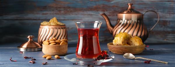 چای ترکی خوشمزه در فنجان شیشه ای با شیرینی روی میز