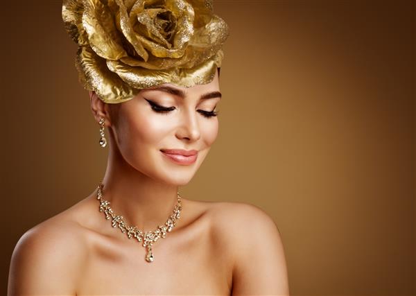 زن زیبا در ست طلایی جواهرات عروسی مدل زیبایی در تاج و گردنبند طلا پرتره صورت دختر مد با آرایش عروس عالی روی پس زمینه قهوه ای