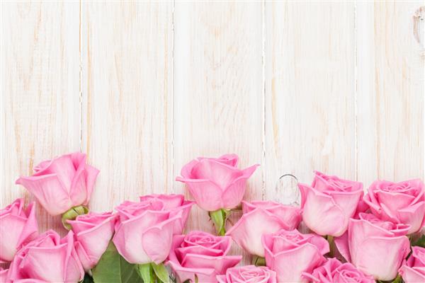 پس زمینه روز ولنتاین با گل رز صورتی روی میز چوبی نمای بالا با فضای کپی