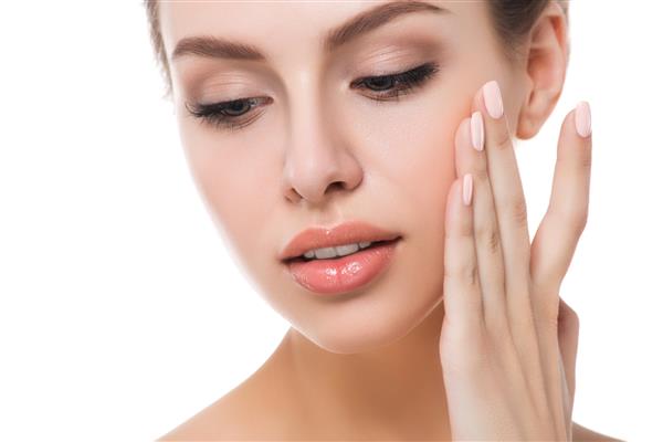 پرتره زن جوان زیبای قفقازی که صورت خود را جدا شده روی پس زمینه سفید لمس می کند پاکسازی صورت پوست کامل مفهوم SPA درمانی مراقبت از پوست زیبایی و جراحی پلاستیک