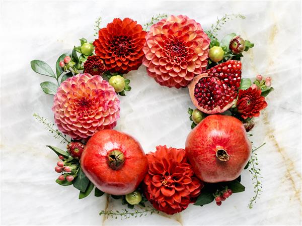 انار قرمز و گل محمدی یک آرایش گل روی کوارتزیت سنگ طبیعی برای سال نو یهودی راش هاشانه تشکیل می دهند