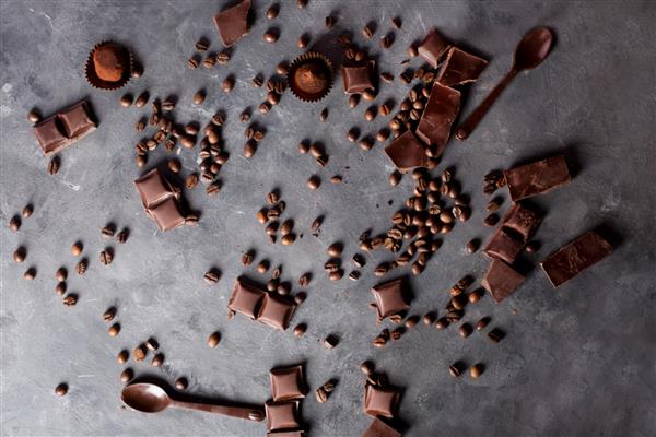 دانه های قهوه با شکلات در زمینه خاکستری