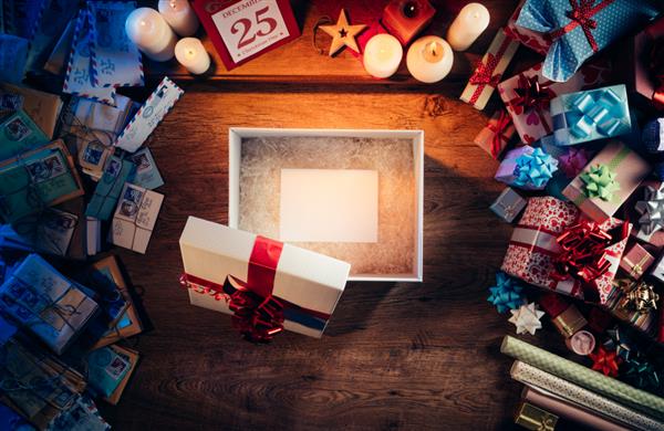 جعبه هدیه را با یک کارت سفید خالی در داخل هدایا و نامه های کریسمس در اطراف نمای بالای دسکتاپ باز کنید