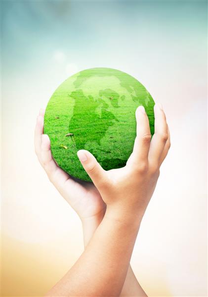مفهوم روز جهانی محیط زیست زمین جهانی از چمن در دو دست انسان در پس زمینه طبیعت تار