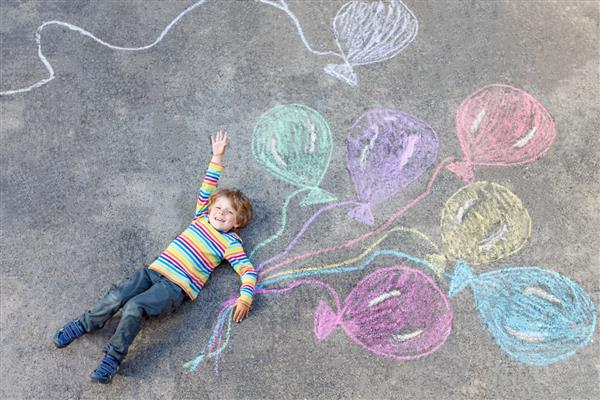 پسر بچه ناز در حال بازی و پرواز با بادکنک های رنگارنگ تصویر نقاشی با گچ اوقات فراغت خلاقانه برای کودکان در تابستان جشن تولد
