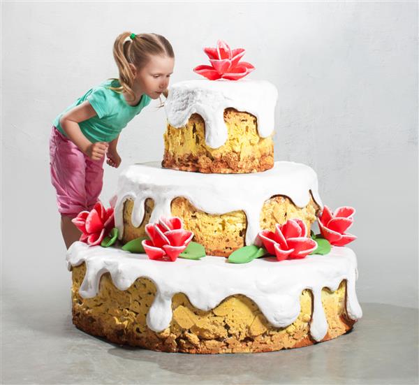 دختر در نزدیکی یک کیک بزرگ