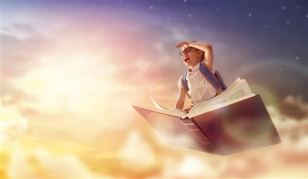 بازگشت به مدرسه کودک پرتلاش و ناز شادی که روی کتاب در پس زمینه آسمان غروب پرواز می کند مفهوم آموزش و خواندن توسعه تخیل